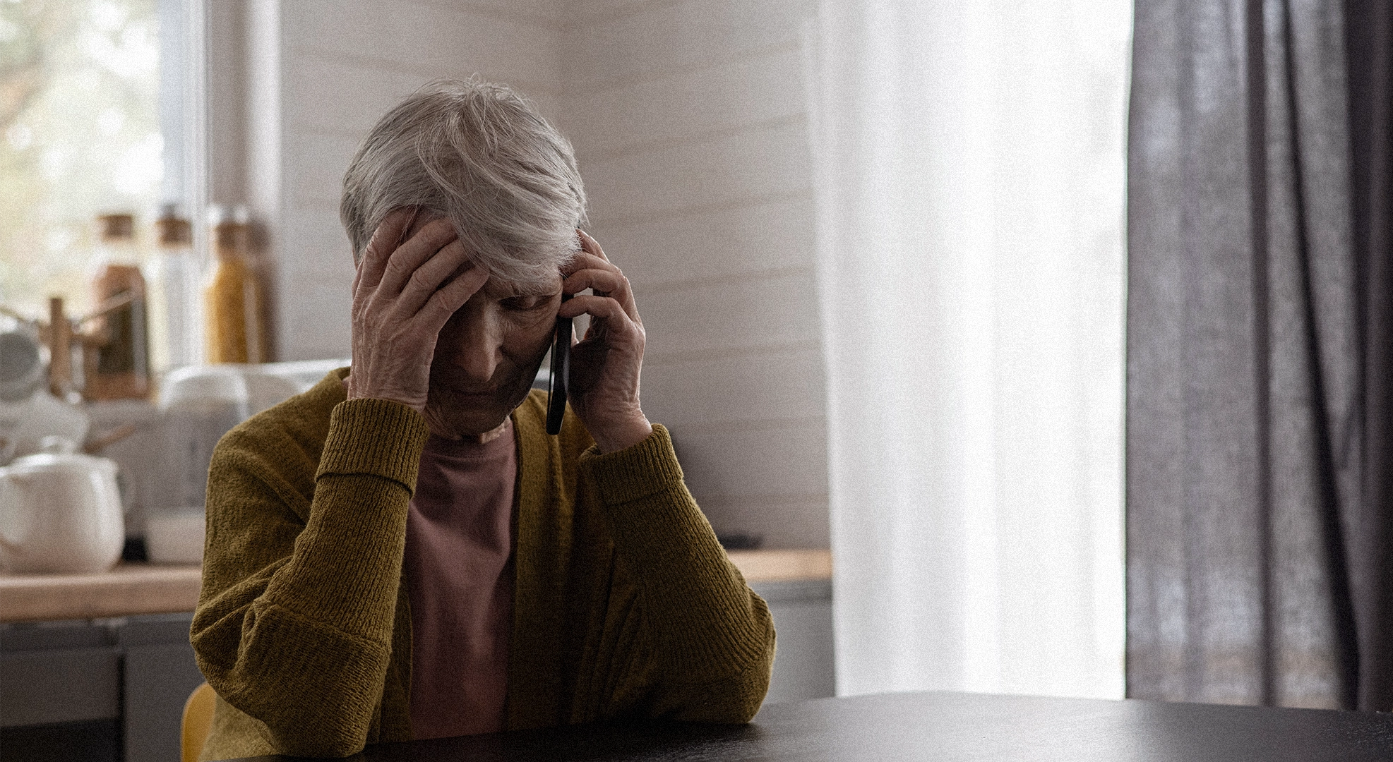 Mujer mayor hablando por teléfono con expresión tensa y gesto de frustración. Simboliza la manipulación emocional y las llamadas cargadas de culpa típicas de una madre narcisista.